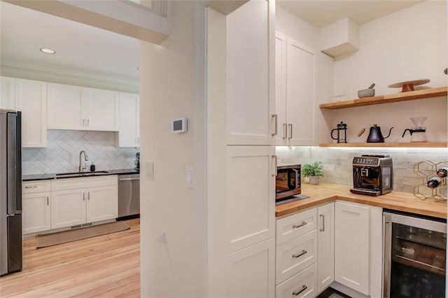 1038 Huntcliff, Atlanta, GA 30350 - bar featuring appliances with stainless steel finishes, a sink, wine cooler, light wood finished floors, and backsplash