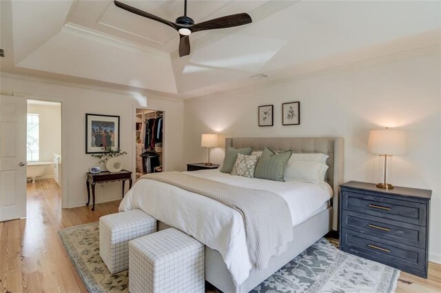 1038 Huntcliff, Atlanta, GA 30350 - bedroom featuring crown molding, a tray ceiling, a spacious closet, and light wood finished floors