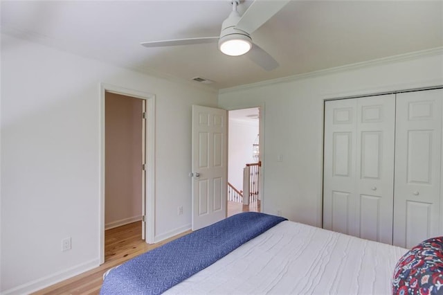 1038 Huntcliff, Atlanta, GA 30350 - bedroom with a closet, ornamental molding, a ceiling fan, visible vents, and wood finished floors