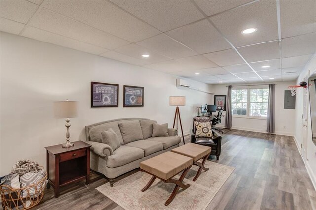 1038 Huntcliff, Atlanta, GA 30350 - living room with a wall unit AC, a drop ceiling, recessed lighting, wood finished floors, and baseboards