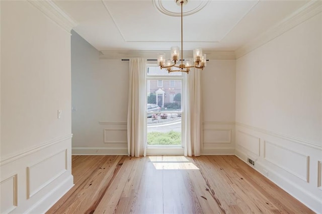 1038 Huntcliff, Atlanta, GA 30350 - unfurnished dining area with light wood-type flooring, a decorative wall, a notable chandelier, and ornamental molding