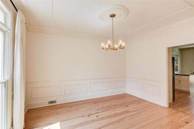 1038 Huntcliff, Atlanta, GA 30350 - spare room featuring crown molding, light wood-type flooring, a decorative wall, and a chandelier
