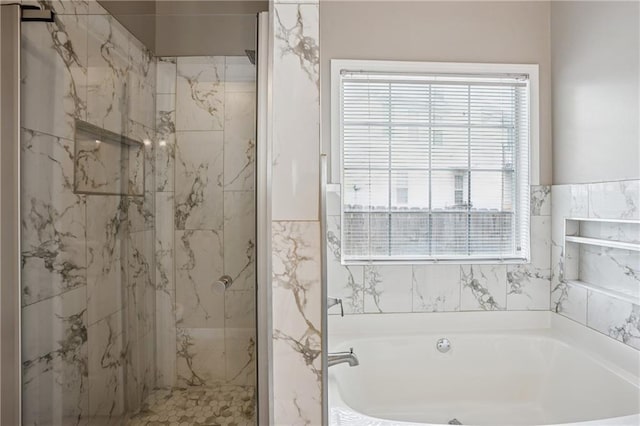 full bath featuring a bath and a marble finish shower