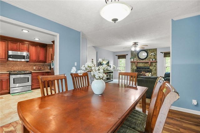 150 Victoria Sta, Woodstock, GA 30189 - dining area featuring a ceiling fan, a fireplace, baseboards, a textured ceiling, and light wood-type flooring