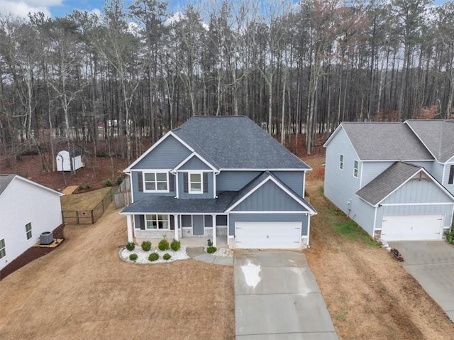 view of front of home featuring central AC, a porch, a garage, and a front yard