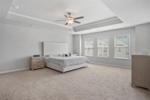 carpeted bedroom featuring a raised ceiling, ornamental molding, and ceiling fan