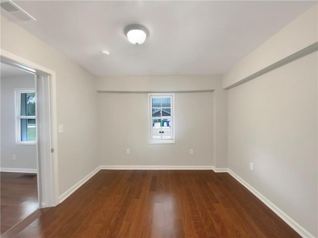 unfurnished room with dark wood-type flooring