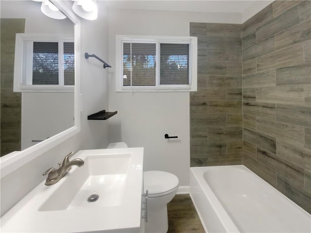 full bathroom with sink, shower / tub combination, wood-type flooring, and toilet