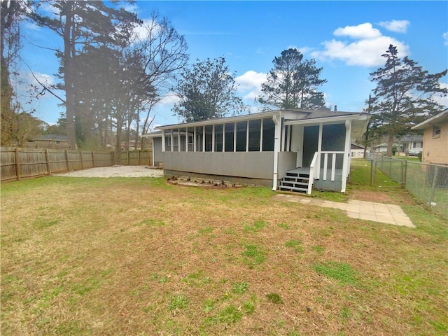 rear view of property featuring a sunroom and a lawn