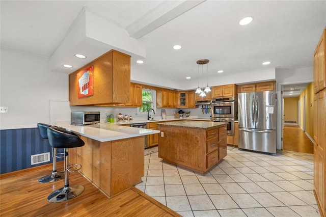 1690 Cedar Grove Dr, Marietta, GA 30066 - kitchen featuring stainless steel appliances, brown cabinets, a peninsula, recessed lighting, and light countertops
