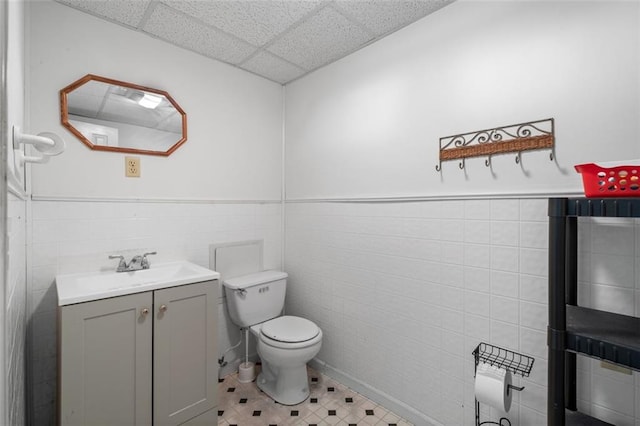 1690 Cedar Grove Dr, Marietta, GA 30066 - bathroom featuring tile walls, toilet, vanity, a wainscoted wall, and a drop ceiling