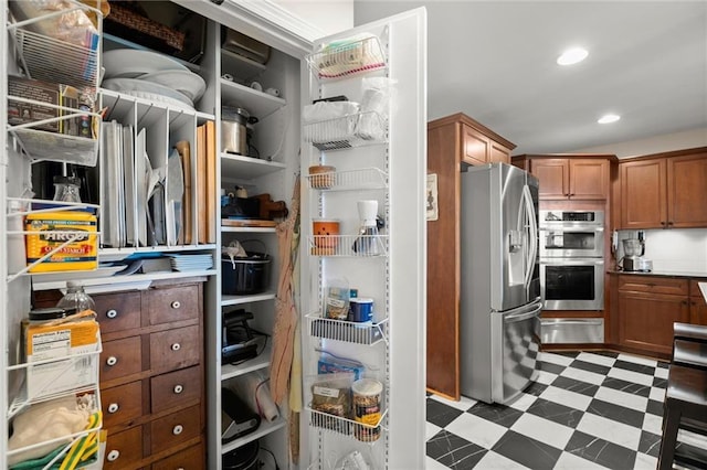 3330 Overland Dr, Roswell, GA 30075 - kitchen featuring appliances with stainless steel finishes, a warming drawer, tile patterned floors, brown cabinets, and recessed lighting