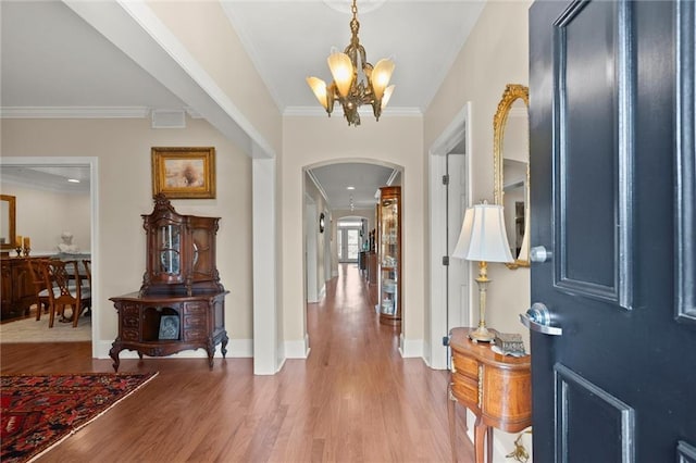3330 Overland Dr, Roswell, GA 30075 - entrance foyer featuring arched walkways, a chandelier, crown molding, light wood-style floors, and baseboards