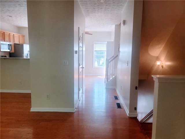 523 Lantern Wood Dr, Scottdale, GA 30079 - hall with a textured ceiling, baseboards, visible vents, and wood finished floors