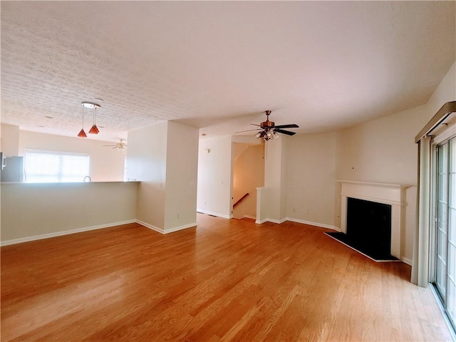 523 Lantern Wood Dr, Scottdale, GA 30079 - unfurnished living room featuring a ceiling fan, a fireplace with raised hearth, and a healthy amount of sunlight