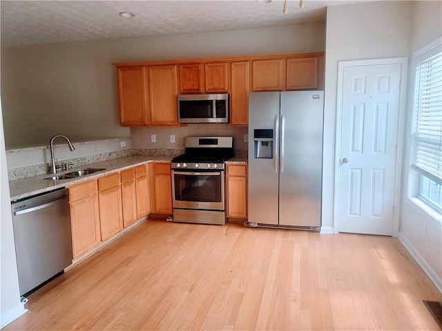 523 Lantern Wood Dr, Scottdale, GA 30079 - kitchen with decorative backsplash, appliances with stainless steel finishes, light stone countertops, a sink, and light wood-style flooring