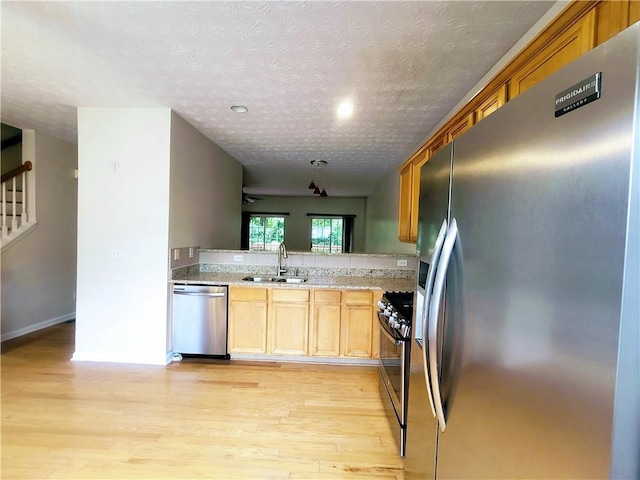 523 Lantern Wood Dr, Scottdale, GA 30079 - kitchen featuring a textured ceiling, appliances with stainless steel finishes, a sink, and light wood finished floors