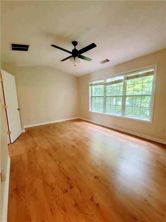 523 Lantern Wood Dr, Scottdale, GA 30079 - unfurnished room featuring baseboards, light wood-style flooring, ceiling fan, and visible vents