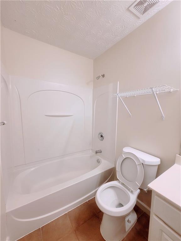523 Lantern Wood Dr, Scottdale, GA 30079 - bathroom featuring vanity, toilet, tile patterned floors, shower / bath combination, and visible vents