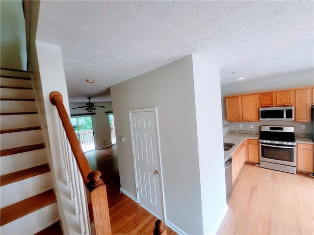 523 Lantern Wood Dr, Scottdale, GA 30079 - stairway with a ceiling fan, a textured ceiling, and wood finished floors