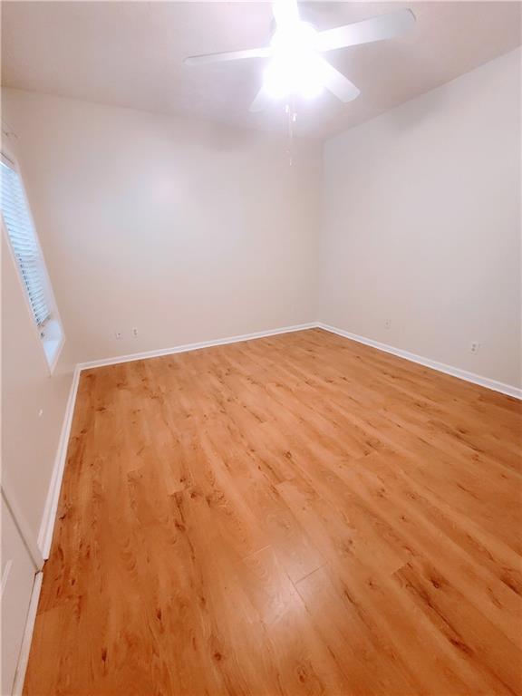 523 Lantern Wood Dr, Scottdale, GA 30079 - empty room with baseboards, ceiling fan, and light wood-style flooring
