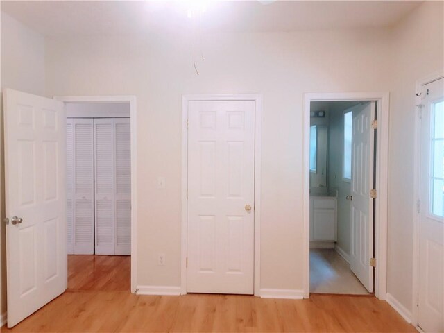 523 Lantern Wood Dr, Scottdale, GA 30079 - unfurnished bedroom with baseboards, light wood-type flooring, and connected bathroom