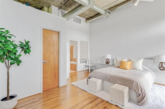 3235 Roswell Rd NE Unit 702, Atlanta, GA 30305 - bedroom featuring a towering ceiling and wood finished floors