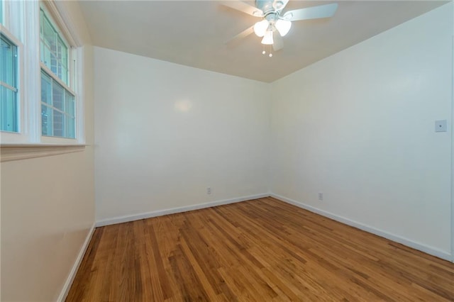 unfurnished room featuring wood finished floors, a ceiling fan, and baseboards