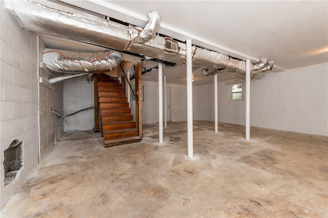 basement featuring concrete block wall and visible vents