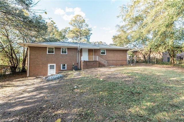 rear view of property with brick siding and fence