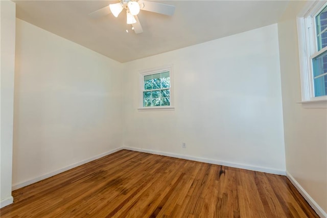 empty room featuring a ceiling fan, baseboards, and wood finished floors