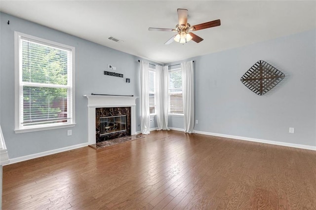213 Roseman Way, Woodstock, GA 30188 - unfurnished living room featuring a ceiling fan, a high end fireplace, wood finished floors, and plenty of natural light