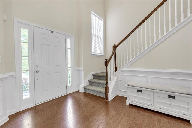 213 Roseman Way, Woodstock, GA 30188 - entrance foyer with wood finished floors, stairs, wainscoting, a decorative wall, and a high ceiling