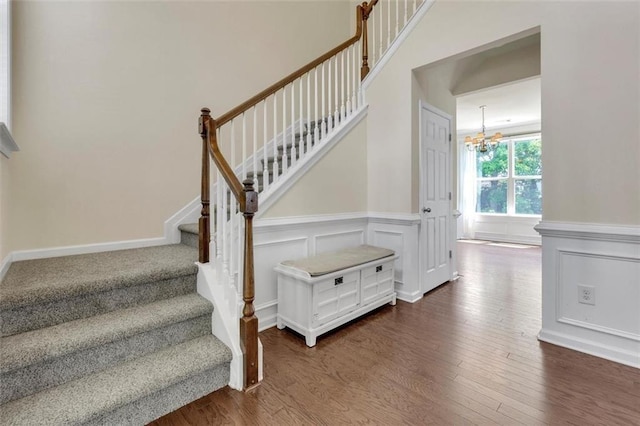 213 Roseman Way, Woodstock, GA 30188 - stairs with a chandelier, a wainscoted wall, wood finished floors, and a decorative wall