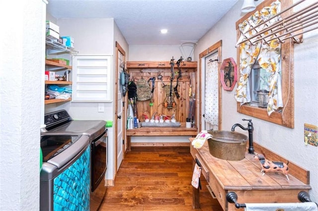 washroom with a textured ceiling, dark hardwood / wood-style flooring, washer and clothes dryer, and sink