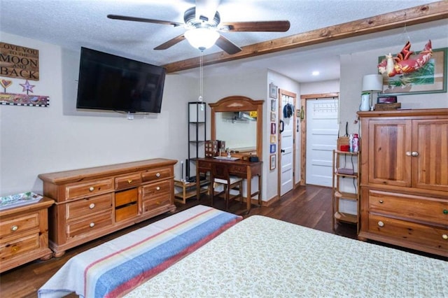 bedroom with beam ceiling, ceiling fan, dark hardwood / wood-style flooring, and a textured ceiling