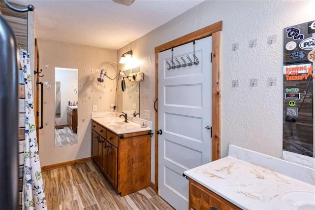 bathroom featuring wood-type flooring, vanity, and a textured ceiling