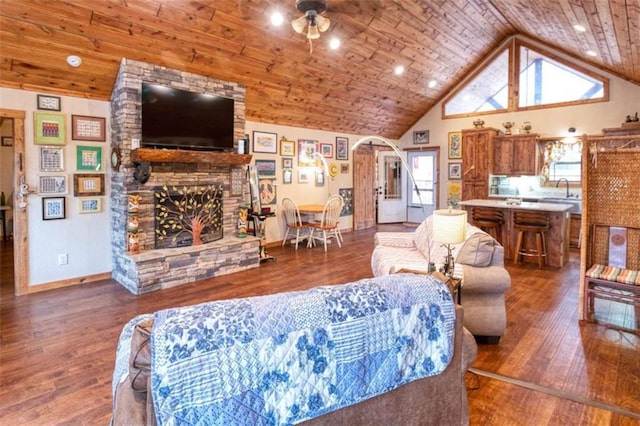 living room featuring ceiling fan, dark hardwood / wood-style flooring, wooden ceiling, and a fireplace