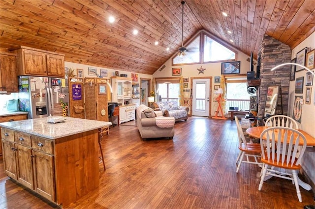 kitchen featuring a center island, light stone counters, high vaulted ceiling, stainless steel refrigerator with ice dispenser, and wood ceiling