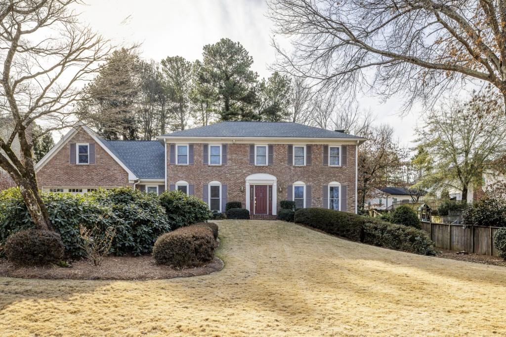 colonial-style house featuring a front lawn