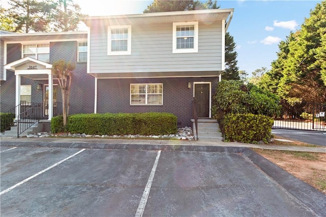 townhome / multi-family property featuring uncovered parking and brick siding
