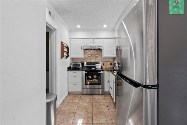 kitchen featuring stainless steel appliances, under cabinet range hood, dark countertops, a textured ceiling, and white cabinetry