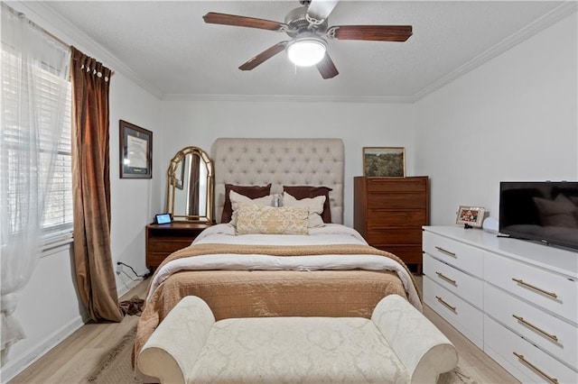 bedroom with light wood-style floors, ornamental molding, baseboards, a ceiling fan, and a textured ceiling