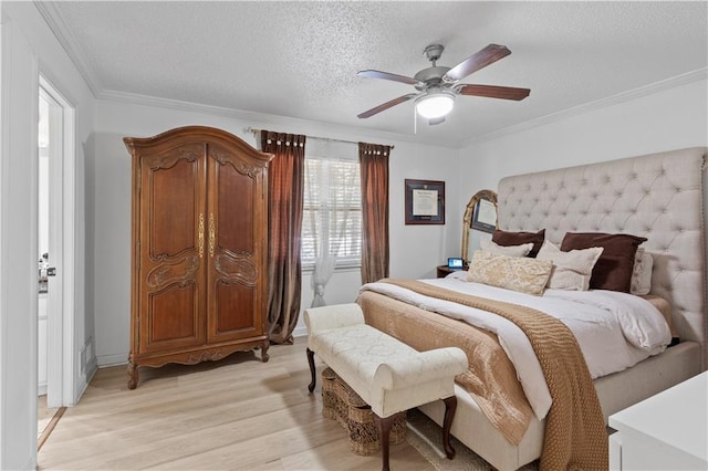 bedroom with light wood-style floors, a textured ceiling, crown molding, and a ceiling fan