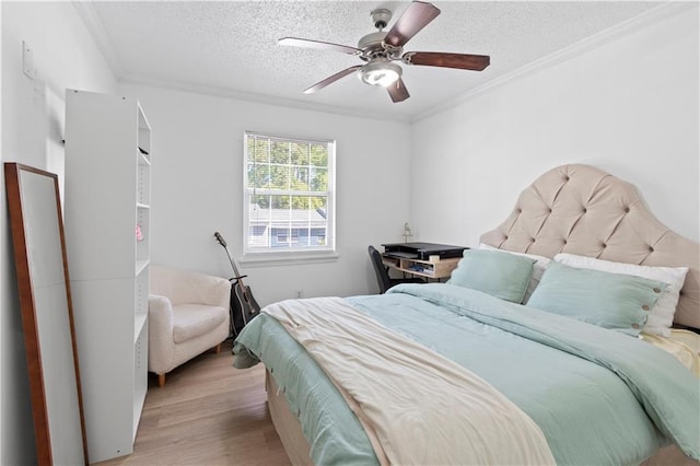 bedroom featuring crown molding, a textured ceiling, light wood-style flooring, and a ceiling fan