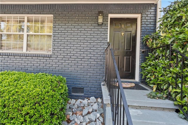 entrance to property with crawl space and brick siding