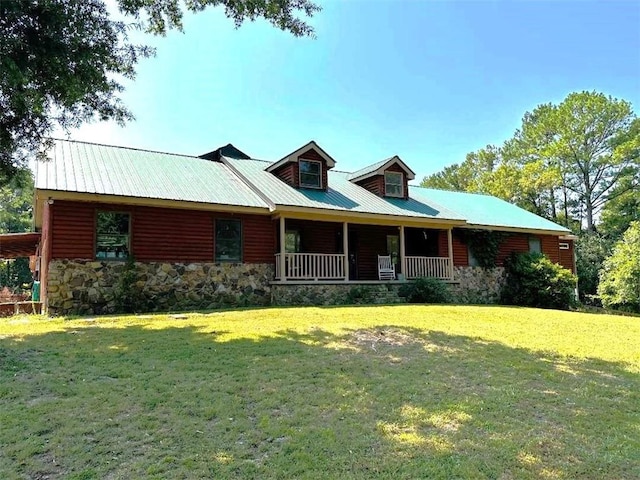 view of front of house featuring stone siding, metal roof, and a front yard