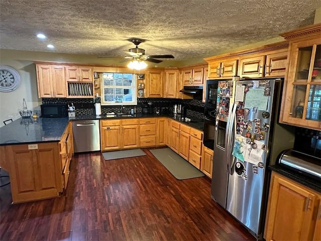 kitchen with dark hardwood / wood-style flooring, backsplash, appliances with stainless steel finishes, sink, and ceiling fan