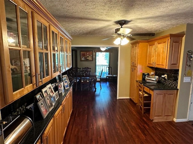 kitchen featuring decorative backsplash, a ceiling fan, baseboards, and dark wood-style flooring