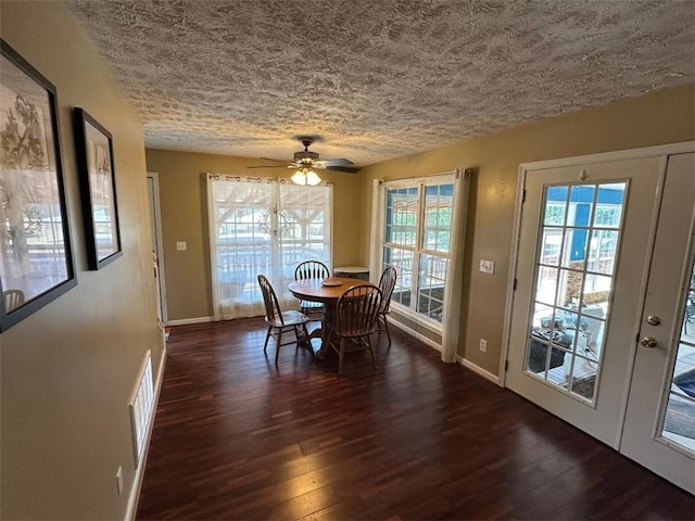 unfurnished dining area with dark wood-type flooring, ceiling fan, and a textured ceiling